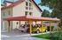 Skan Holz Doppelcarport Wendland 630x879 cm 216 cm Einfahrtshöhe mit Aluminiumdach rote Blende Eiche hell